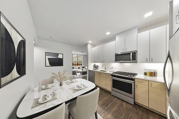 A modern kitchen with a dining table set for two.